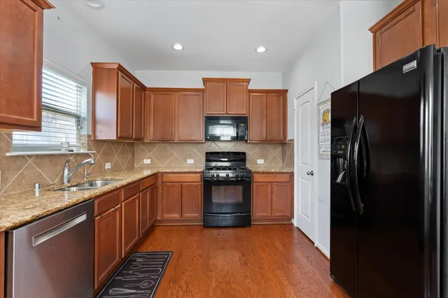 a kitchen with stainless steel appliances granite countertop a refrigerator and a sink