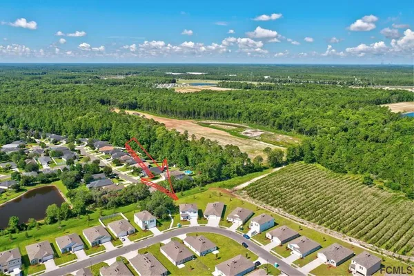 an aerial view of a residential houses with yard