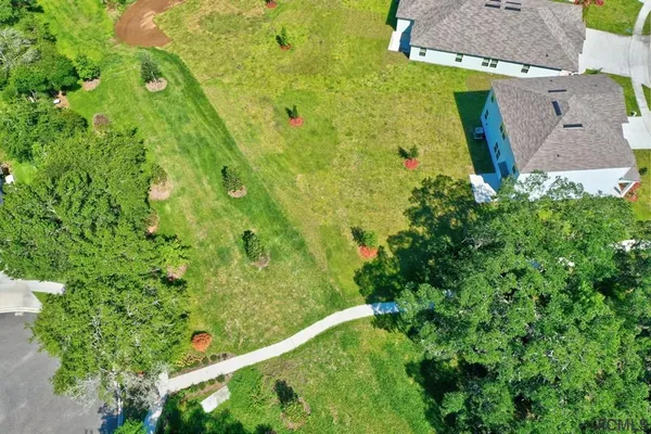 a large white kitchen with wooden floor and stainless steel appliances