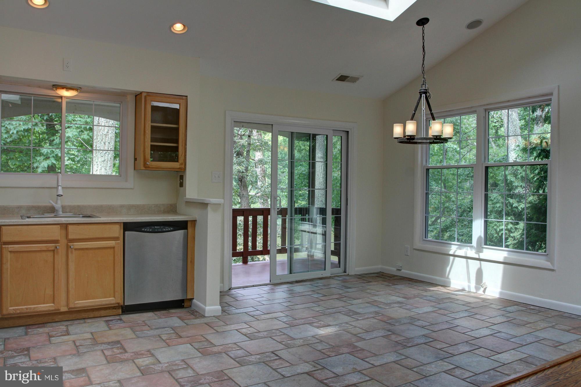 a open kitchen with granite countertop a sink window and cabinets
