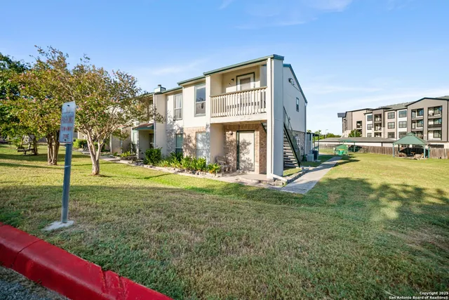 a view of a house with a big yard and large trees