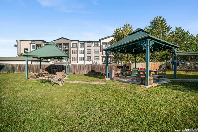 a view of a house with backyard and sitting area