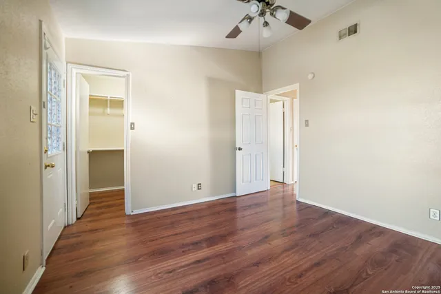 a view of an empty room with wooden floor
