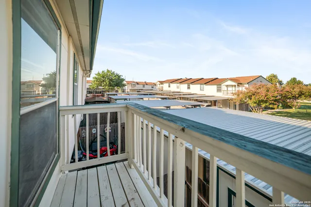a view of a balcony with wooden floor and fence
