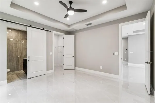 an empty room with windows and ceiling fan