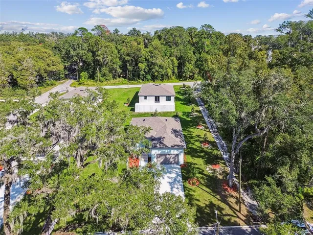 an aerial view of a house with swimming pool garden and patio