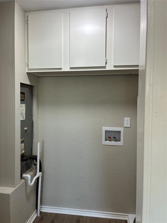 5066 East Highway 199 Springtown, TX 76082 - Photo 15 of 15 Laundry room with cabinet space, next to kitchen, vinyl floors, a textured wall, and washer and dryer hookups and water heater