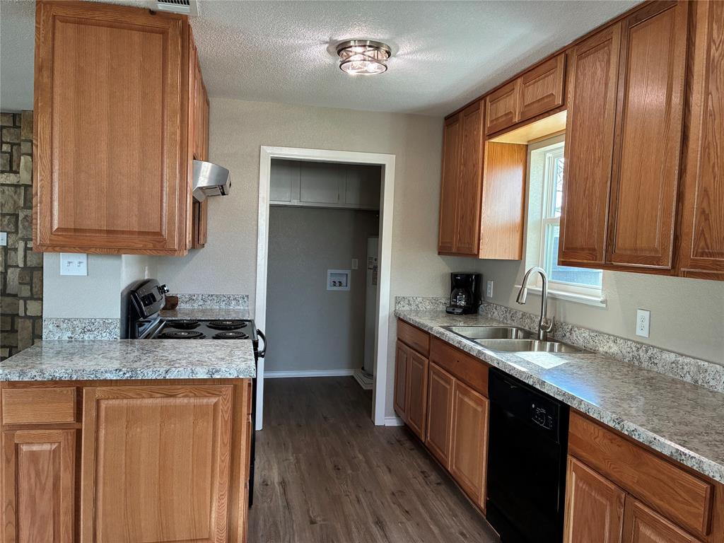 5066 East Highway 199 Springtown, TX 76082 - Photo 5 of 15 Kitchen with wood finish cabinets, black appliances, dark wood-style flooring, exhaust hood, and a textured ceiling