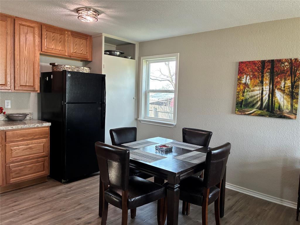 5066 East Highway 199 Springtown, TX 76082 - Photo 7 of 15 Dining space featuring a textured wall, a textured ceiling, and viynl looring