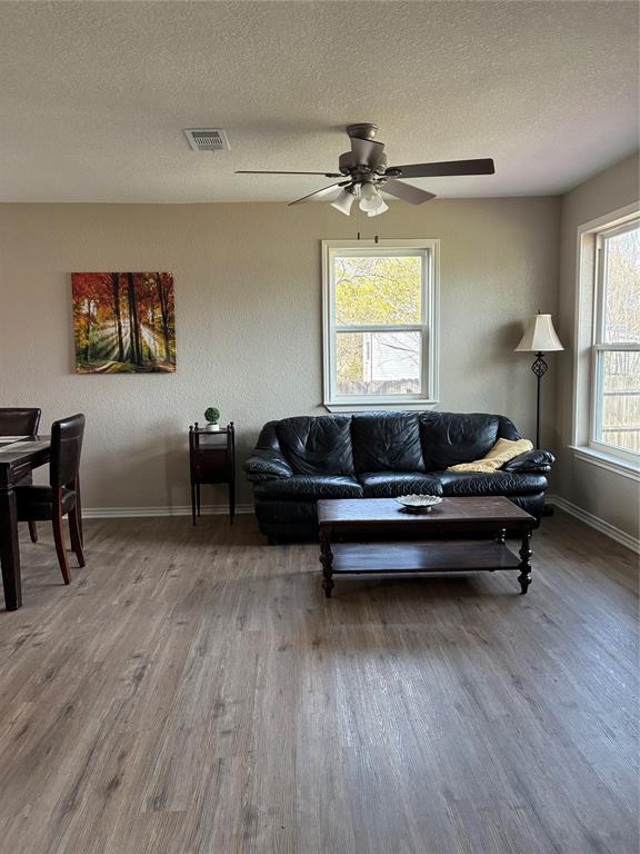 5066 East Highway 199 Springtown, TX 76082 - Photo 9 of 15 Living area featuring vinyl flooring, a textured ceiling, and ceiling fan