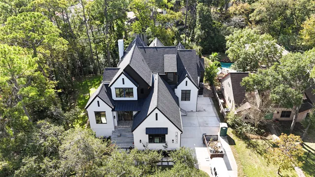 an aerial view of a house with a big yard and large trees