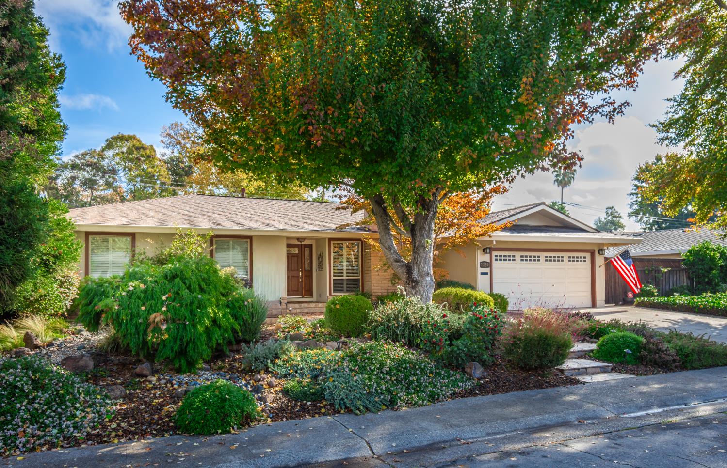 a front view of a house with a yard and potted plants