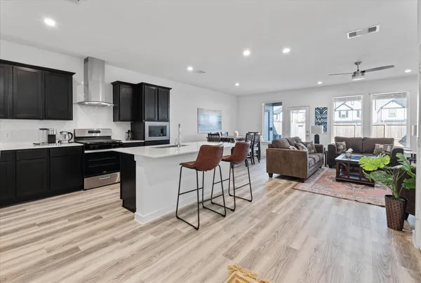 a living room with furniture a flat screen tv and kitchen view