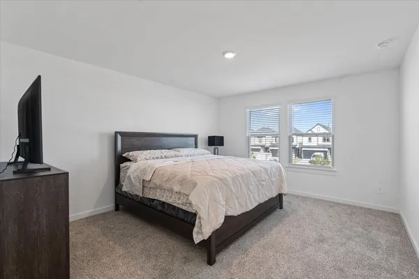 a spacious bedroom with a bed and a flat screen tv