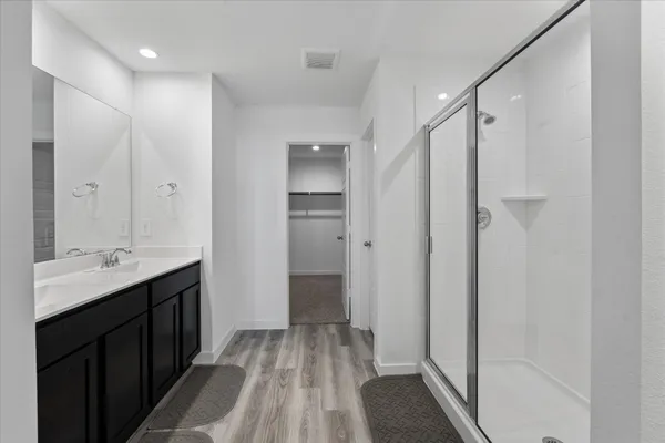 a bathroom with a shower sink and mirror