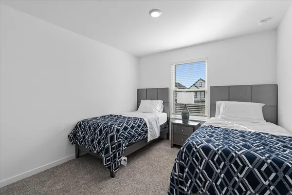 a bedroom with two beds and a lamp