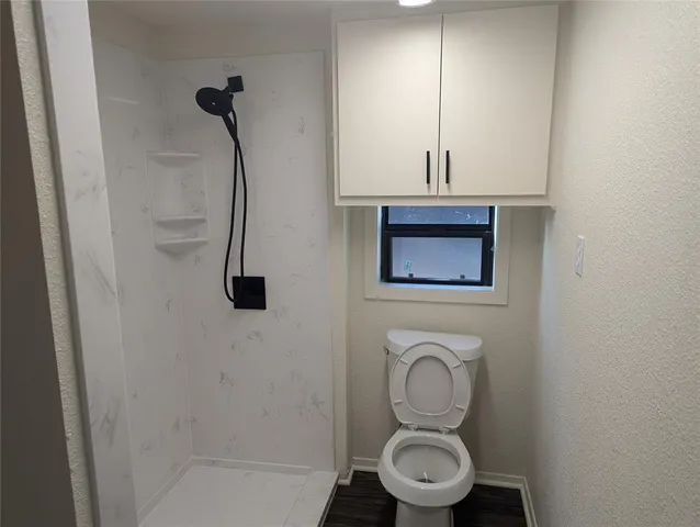 a bathroom with a toilet and a shower