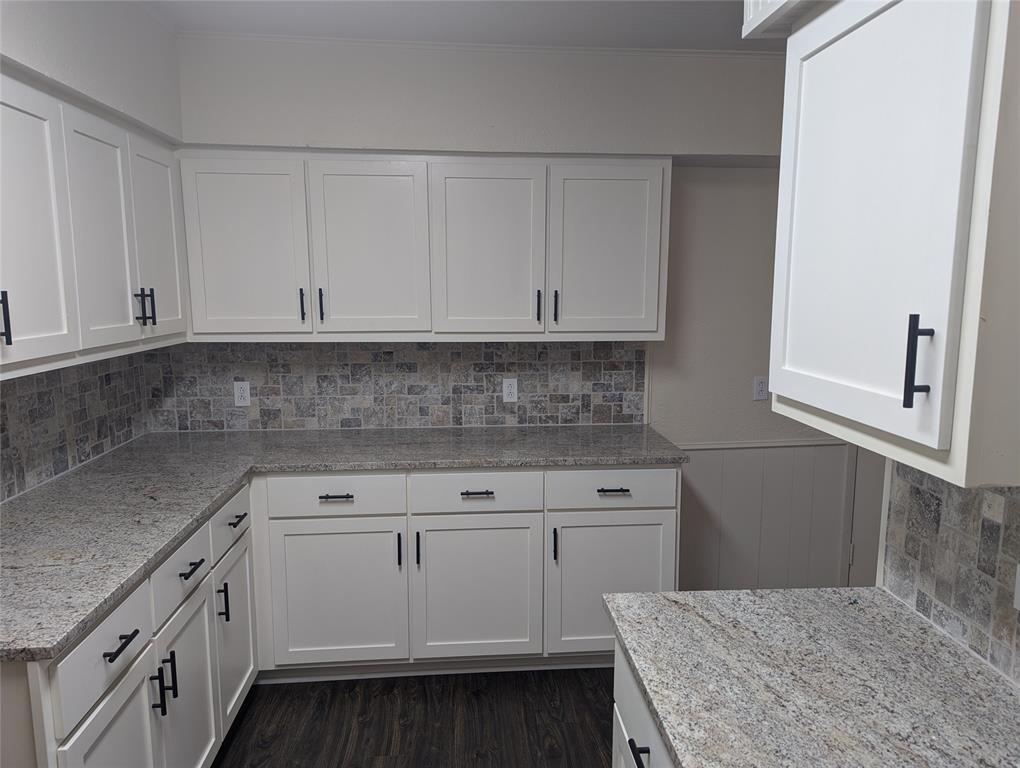 502 East Baker Street Hamilton, TX 76531 - Photo 34 of 37 a kitchen with white cabinets and white appliances