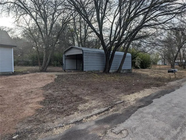 a view of a house with a large tree and a yard