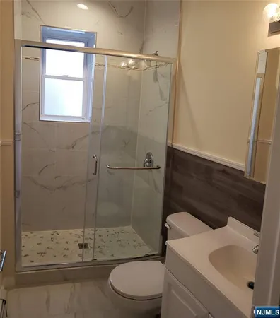 a bathroom with a shower a toilet and a sink