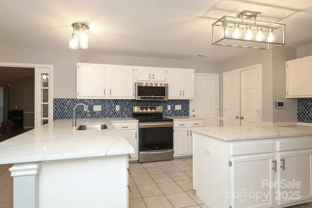 a kitchen with stainless steel appliances a stove refrigerator sink and microwave