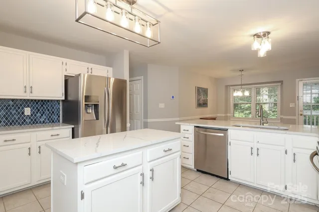 a kitchen with white cabinets and refrigerator