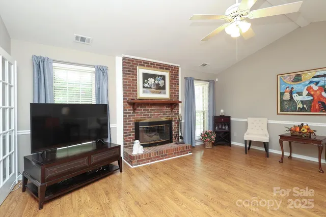 a living room with furniture ceiling fan and a fireplace