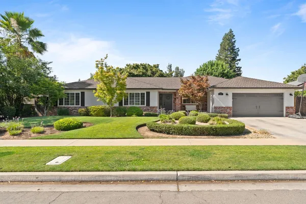 a front view of a house with a garden and plants