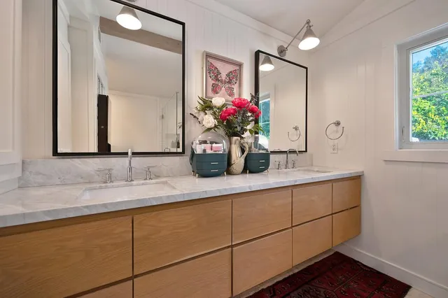 a bathroom with a granite countertop sink and a mirror