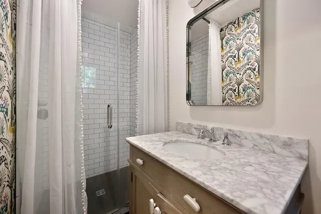 a bathroom with a granite countertop sink and a mirror