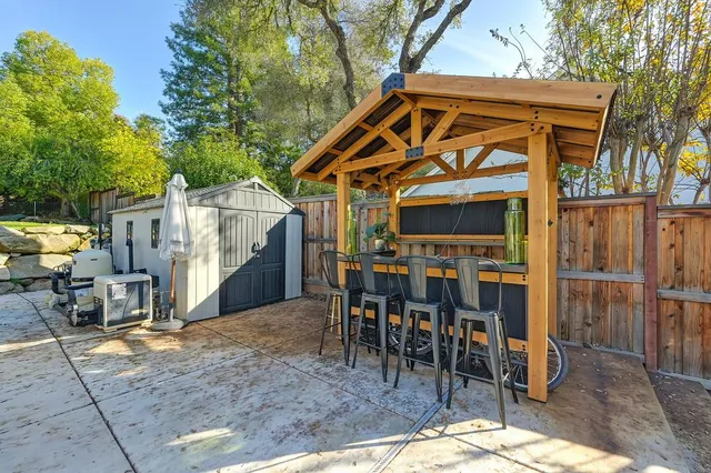a view of a patio with a dining table and chairs under an umbrella