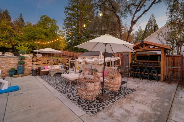 a view of a patio with chairs under an umbrella