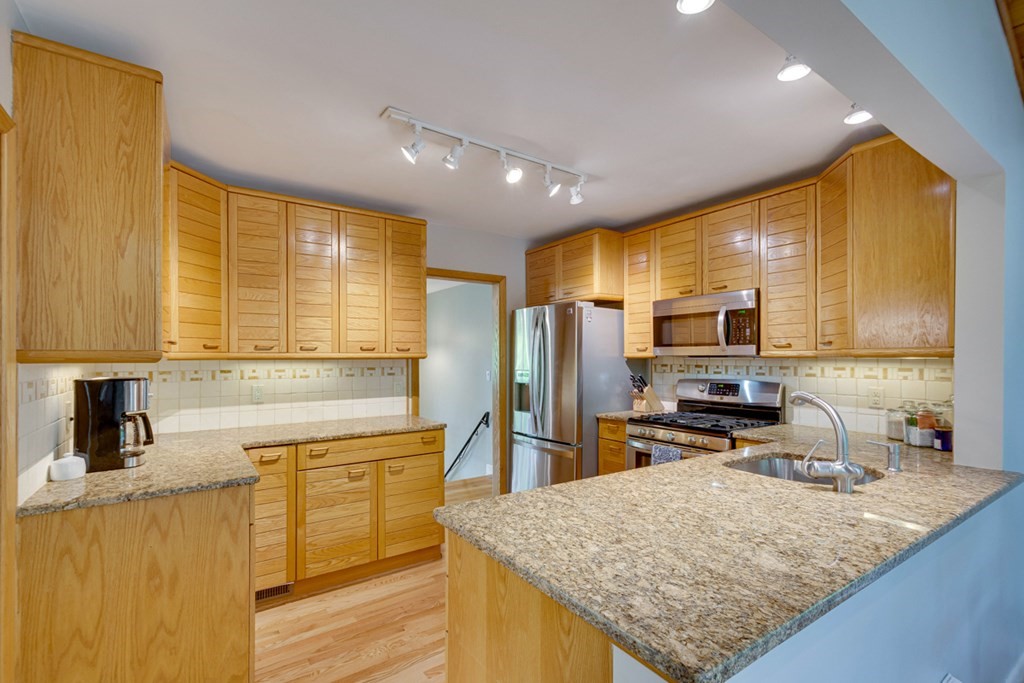 65 Angelica Drive Framingham, MA 01701 - Photo 15 of 34 a kitchen with stainless steel appliances granite countertop sink stove top oven and refrigerator