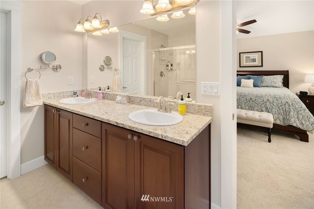 a en suite bathroom with a granite countertop sink and a mirror