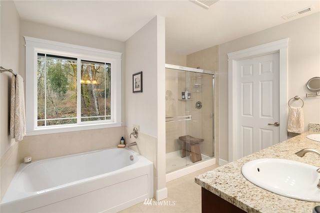 a bathroom with a granite countertop tub sink and shower
