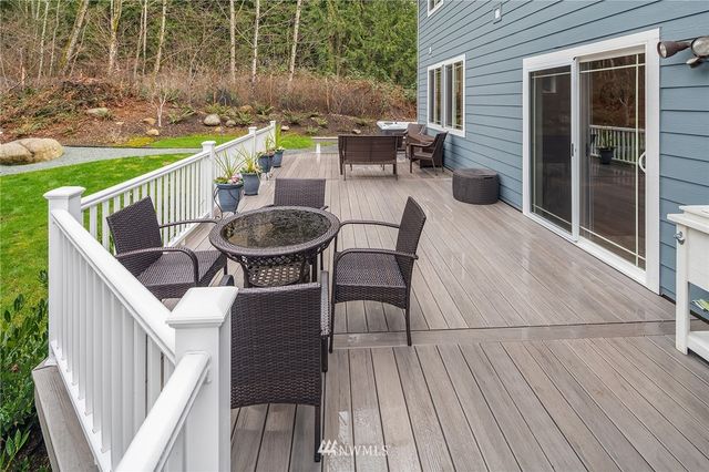 a view of a patio with table and chairs with wooden floor and fence