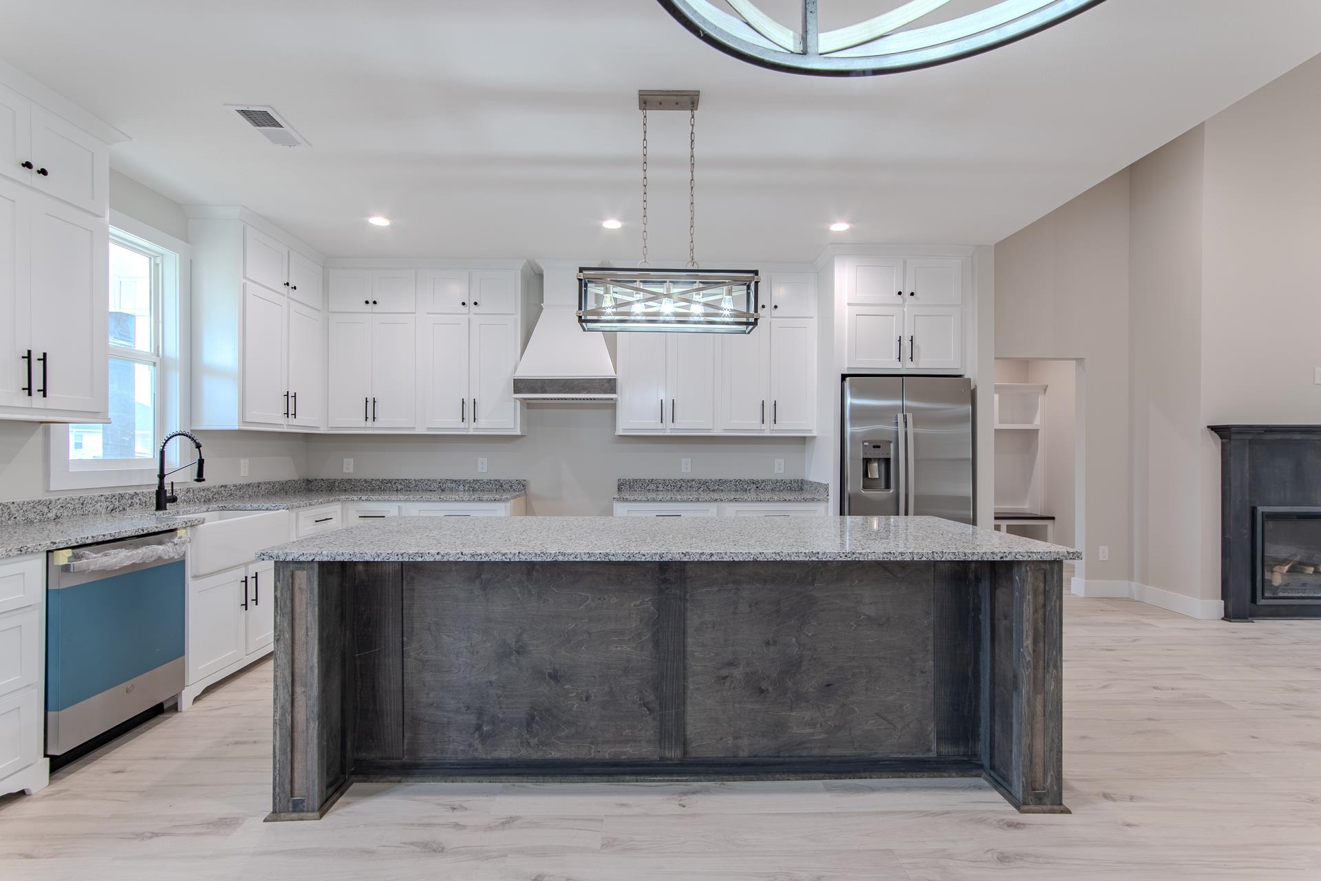 a kitchen with stainless steel appliances granite countertop a sink a stove and a wooden floors