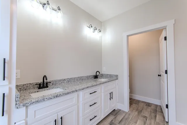a bathroom with a granite countertop sink and a mirror