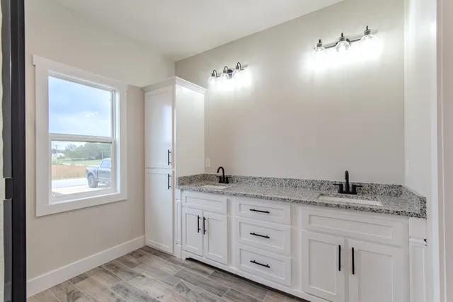 a bathroom with a granite countertop sink and a mirror