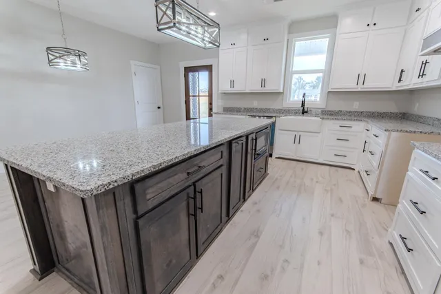 a kitchen with stainless steel appliances granite countertop a sink stove and cabinets