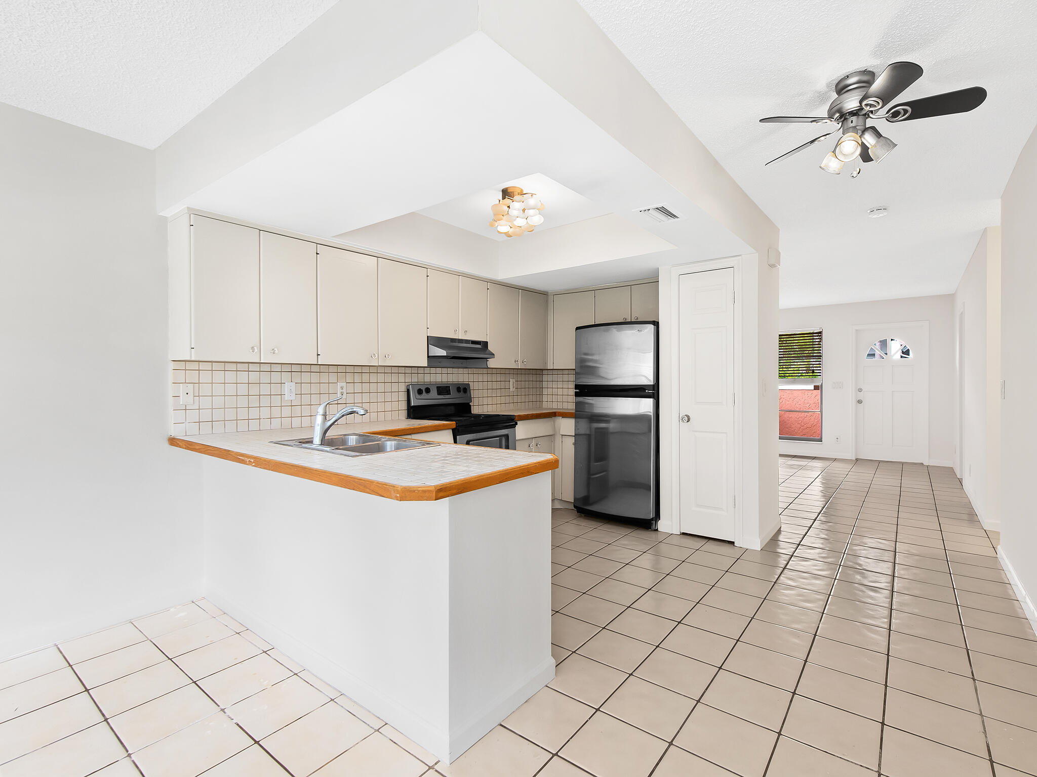 280 Northeast Wavecrest Way Boca Raton, FL 33432 - Photo 6 of 29 a kitchen with stainless steel appliances a refrigerator sink and cabinets