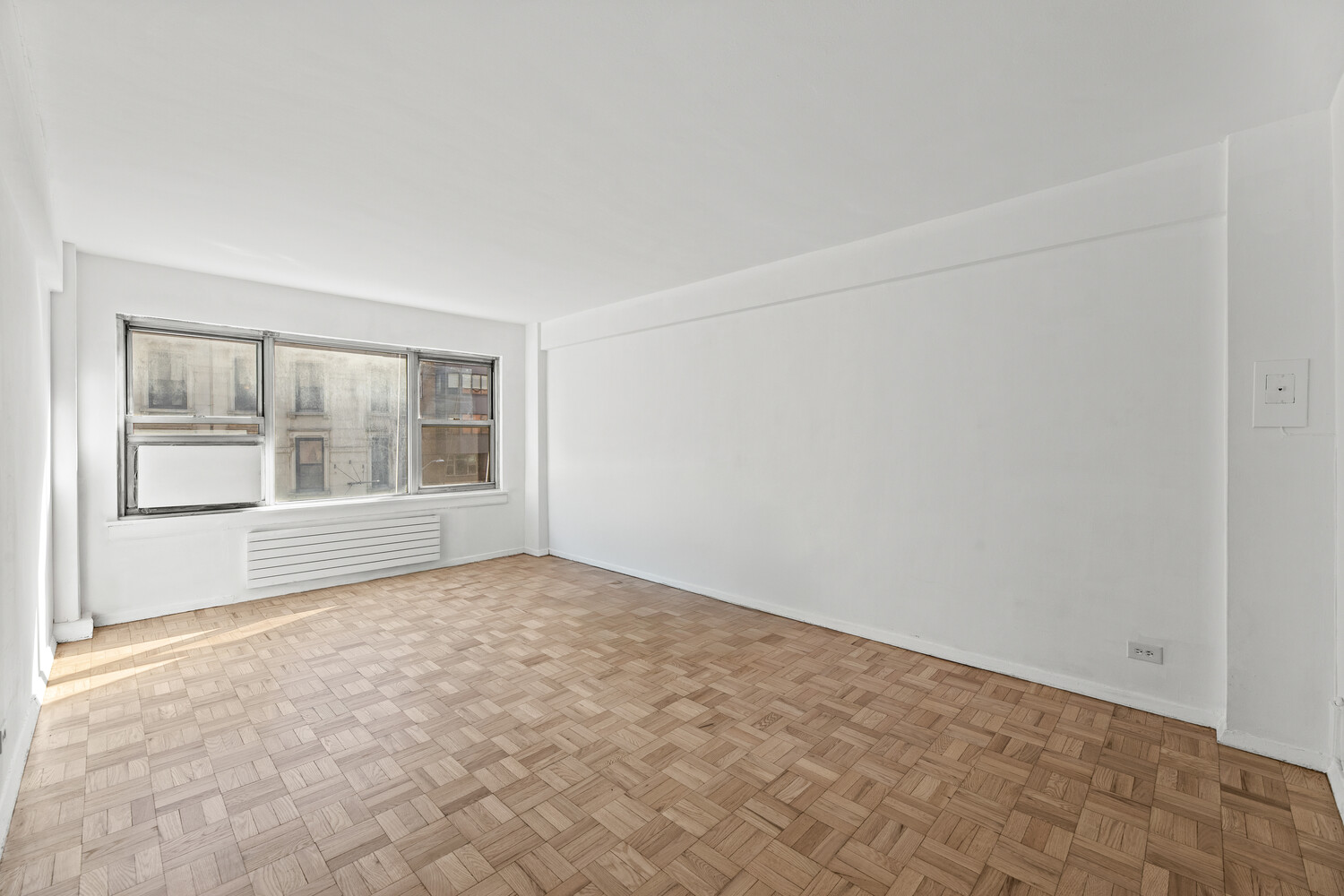 288 Lexington Avenue, Unit 3B Manhattan, NY 10016 - Photo 8 of 10 an empty room with wooden floor and windows