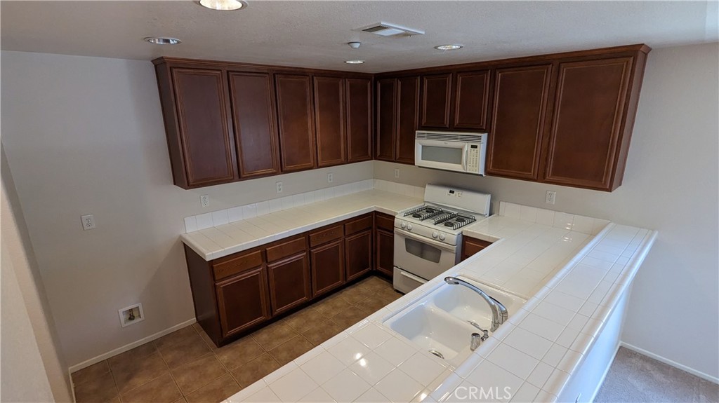 25862 Iris Avenue, Unit B Moreno Valley, CA 92551 - Photo 13 of 23 a kitchen with wooden cabinets and a stove top oven