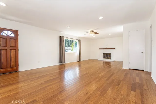a view of empty room with wooden floor and fireplace
