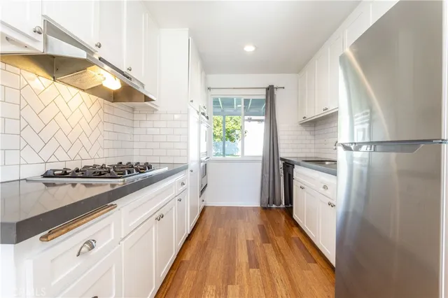 a kitchen with granite countertop white cabinets and white appliances