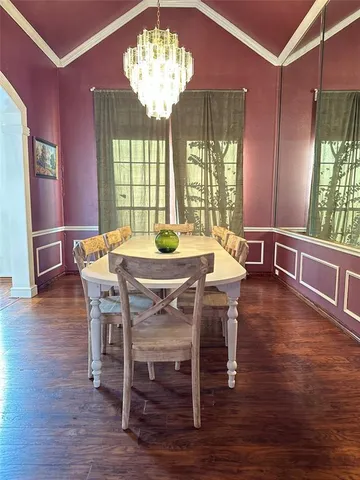 a view of a dining room with furniture wooden floor and chandelier