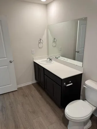 a bathroom with a sink vanity mirror and toilet