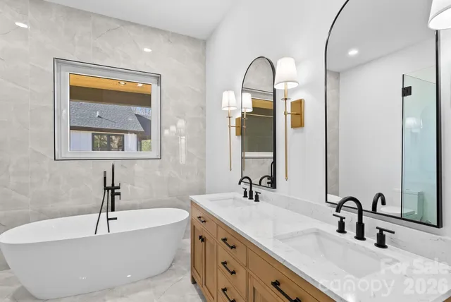 a bathroom with a tub a sink and a window