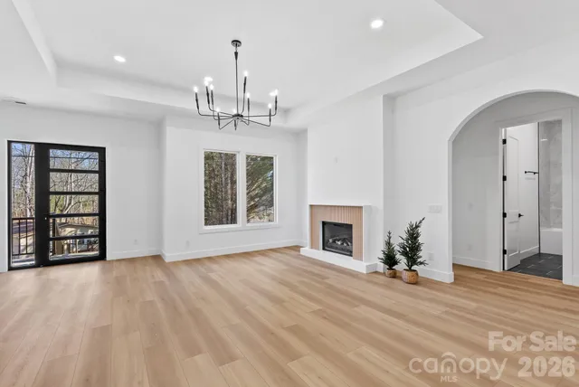 a view of empty room with wooden floor and fireplace