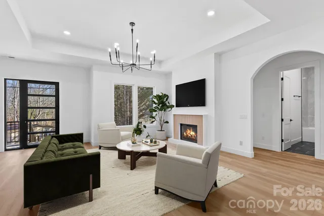 a living room with furniture a chandelier and a fireplace